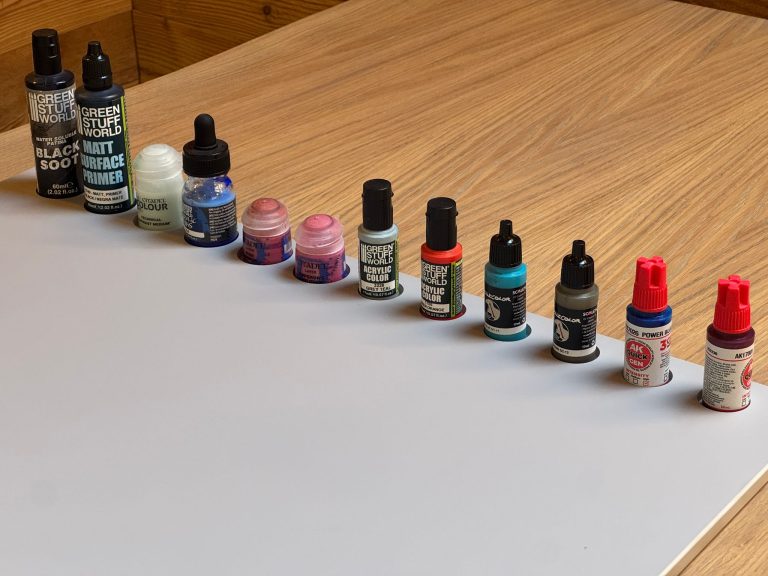 Rangee de peintures sur la palette posee sur une table en chene